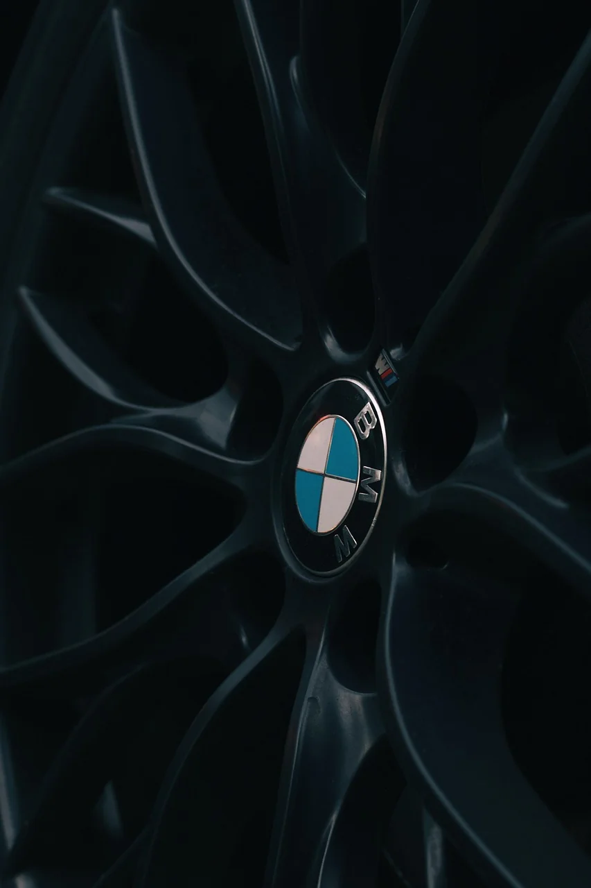 Klasyczne modele Mercedes i BMW zaparkowane obok siebie, reprezentujące ikony motoryzacji dla kolekcjonerów.